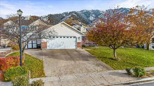 Front facade featuring a mountain view, a garage, and a front yard