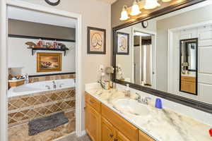 Bathroom featuring vanity and tiled tub