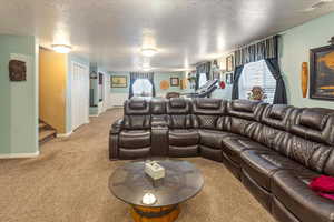 Living room featuring light carpet and a textured ceiling