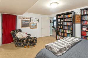 Bedroom with a textured ceiling, carpet floors, and crown molding