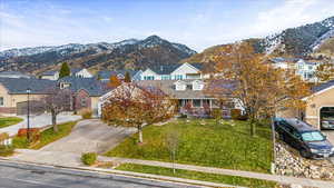 View of front of house with a mountain view and a front yard