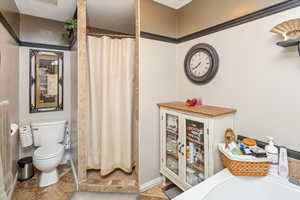 Bathroom featuring a shower with curtain, tile patterned flooring, a textured ceiling, and toilet