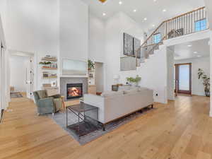 Living room with light hardwood / wood-style floors and a high ceiling