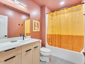 Full bathroom featuring tile patterned floors, vanity, toilet, and shower / bath combo with shower curtain