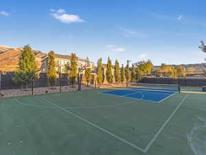 View of basketball court with a mountain view and tennis court