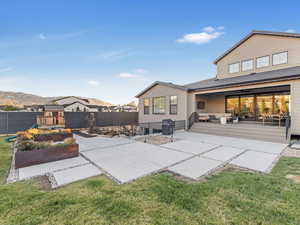 Rear view of property featuring a lawn, a patio area, an outdoor hangout area, and a deck with mountain view