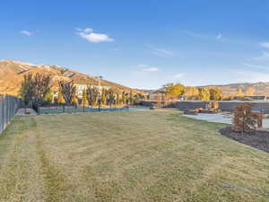 View of yard with a mountain view, tennis court, and a patio