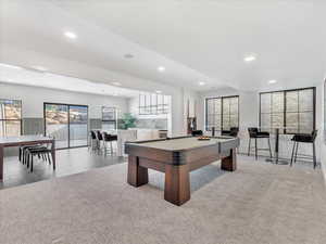 Playroom with light colored carpet, indoor bar, and billiards