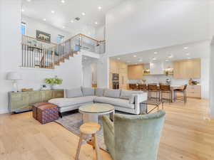 Living room featuring light hardwood / wood-style floors and a high ceiling