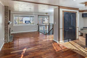 Entrance foyer featuring plenty of natural light, dark wood-type flooring, and a textured ceiling