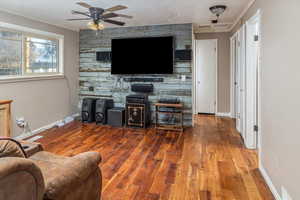 Living room featuring ceiling fan, a textured ceiling, and hardwood / wood-style flooring