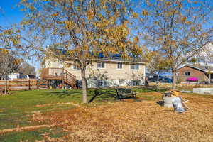 Back of property featuring a lawn and a wooden deck