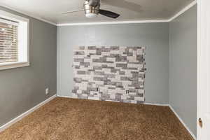 Unfurnished room featuring a textured ceiling, ornamental molding, and carpet floors