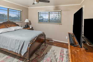 Bedroom featuring wood-type flooring, ceiling fan, and ornamental molding