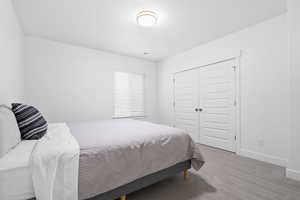 Bedroom featuring light carpet, visible vents, baseboards, and a closet