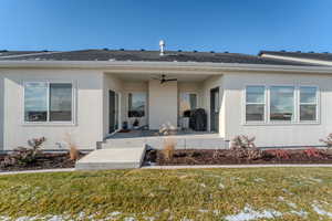 View of rear featuring a yard, ceiling fan, and a patio area