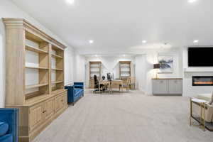 Home office with light carpet, baseboards, a glass covered fireplace, and recessed lighting