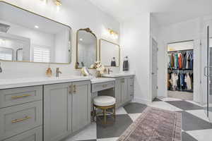 Full bath with vanity, baseboards, a walk in closet, and tile patterned floors