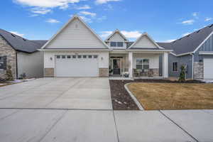 View of front of house with concrete driveway, brick siding, board and batten siding, and an attached garage