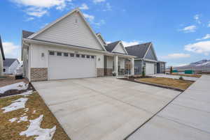 View of front facade with board and batten siding, brick siding, a mountain view, and an attached garage