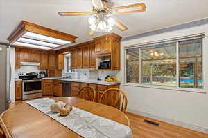 Kitchen with ceiling fan, sink, light wood-type flooring, and appliances with stainless steel finishes