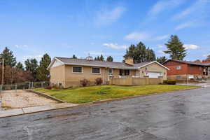 Single story home featuring a garage and a front lawn