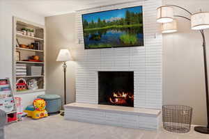 Interior space with carpet and a brick fireplace