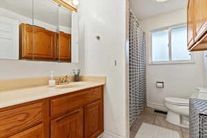 Bathroom with tile patterned floors, vanity, and toilet