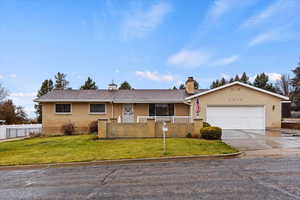 Ranch-style house with a front lawn and a garage