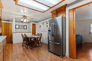 Kitchen featuring ceiling fan, light hardwood / wood-style flooring, and stainless steel refrigerator with ice dispenser