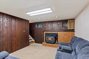 Living room with wood walls and a wood stove