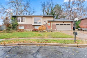 View of front of property featuring a garage and a front yard