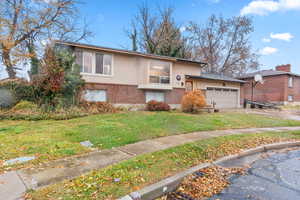 View of front of property featuring a garage and a front yard