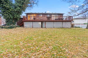 Back of house featuring a deck and a lawn