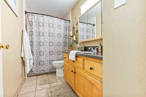 Bathroom with tile patterned floors, vanity, and toilet