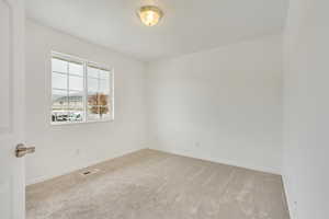 Empty room with light colored carpet