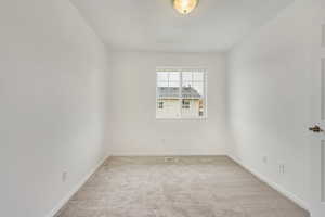 Unfurnished room featuring light colored carpet