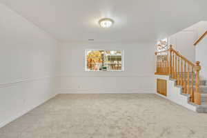 Unfurnished living room with carpet and crown molding