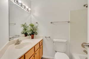 Bathroom featuring a bathing tub, vanity, and toilet