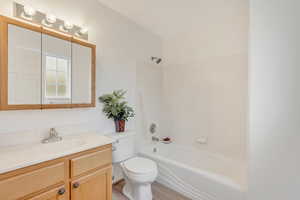 Full bathroom featuring shower / bath combination, vanity, toilet, and wood-type flooring