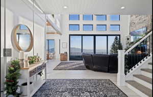 Living room featuring a towering ceiling and light hardwood / wood-style flooring