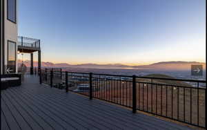 Deck at dusk featuring a mountain view