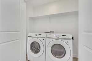 Laundry room featuring hardwood / wood-style floors and separate washer and dryer included