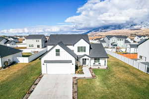 Modern farmhouse featuring a mountain view, a garage, and a front yard