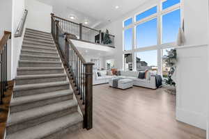 Stairway with a high ceiling and hardwood / wood-style flooring