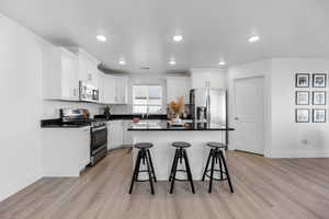 Kitchen featuring white cabinetry, light hardwood / wood-style flooring, and appliances with stainless steel finishes