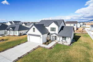 Modern farmhouse featuring a garage and a front lawn