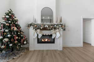 Room details with a tile fireplace and hardwood / wood-style flooring