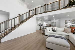 Living room featuring light wood-type flooring and a high ceiling