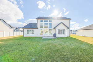 Back of house featuring a lawn and a patio